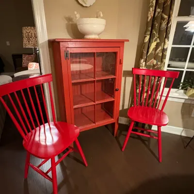 Sale Photo Thumbnail #3: Red painted wooden glass-front display cabinet paired with two matching spindle-back chairs.
