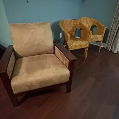 Sale Photo Thumbnail #53: Contemporary upholstered armchair with dark wood frame, alongside a pair of natural wicker accent chairs.