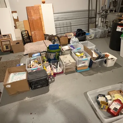 Sale Photo Thumbnail #47: Assorted garage organization items, plastic storage bins, cardboard boxes, and miscellaneous household goods 