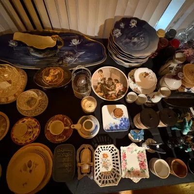 Sale Photo Thumbnail #20: A large collection of vintage porcelain and ceramic tableware, including decorative plates, teacups with saucers, a gravy boat, and trinket dishes.