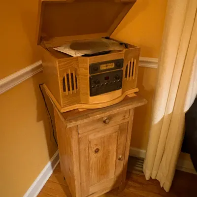 Sale Photo Thumbnail #18: Vintage-style wooden tabletop media player with turntable, cassette, and radio, displayed atop a rustic wooden cabinet.