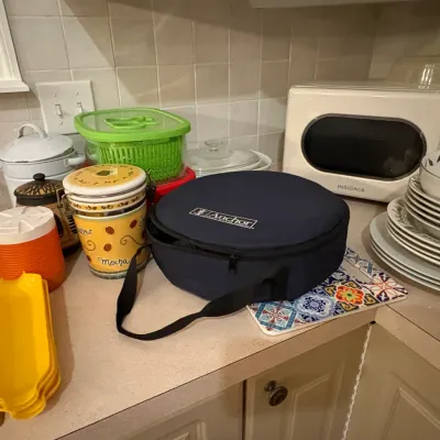 Sale Photo Thumbnail #39: Kitchen countertop assortment including an Anchor Hocking insulated carrier, ceramic canister set, stacked dishes, and a white Insignia microwave.