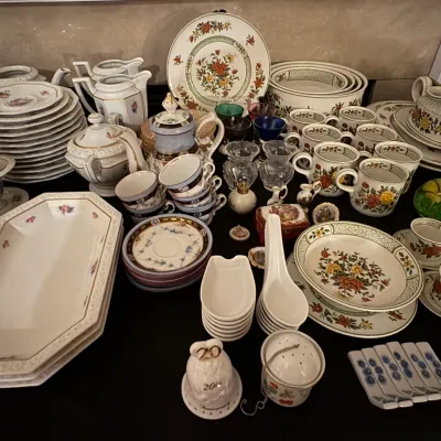 Sale Photo Thumbnail #27: Large collection of vintage porcelain tableware, featuring floral dinnerware sets, teacups, saucers, teapots, serving platters, and decorative bells.