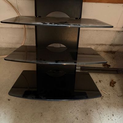 Sale Photo Thumbnail #62: Modern three-tier media component stand featuring a black wooden spine and smoked tempered glass shelves.