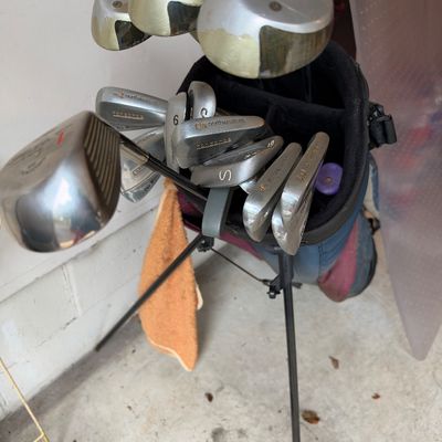 Sale Photo Thumbnail #64: Vintage set of Northwestern golf clubs including irons and drivers stored in a blue and maroon standing golf bag.
