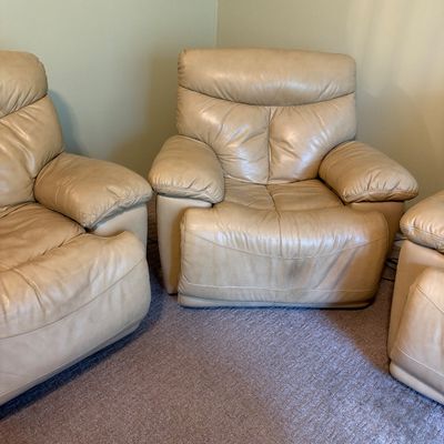 Sale Photo Thumbnail #36: Contemporary beige leather reclining armchair with padded armrests and plush back cushioning, showing light surface wear.