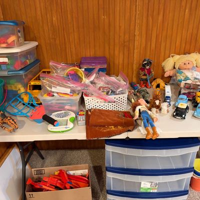 Sale Photo Thumbnail #113: Assortment of vintage and modern children's toys, including a Cabbage Patch Kids doll, Toy Story Jessie figure, die-cast cars, building blocks, and plastic dinosaurs.