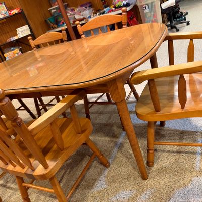 Sale Photo Thumbnail #111: Light oak dining table featuring a glass protective top accompanied by matching spindle-back chairs.