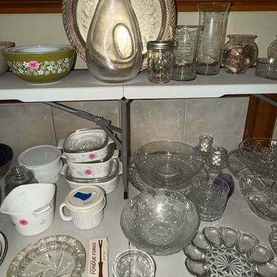 Sale Photo Thumbnail #75: Collection of vintage glassware and kitchen items, featuring Pyrex nesting bowls, CorningWare casseroles, clear glass serving pieces, and an Oster fondue fork set.