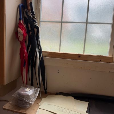 Sale Photo Thumbnail #13: Collection of baseball equipment including rubber pitcher's plates and home bases alongside a group of assorted full-size umbrellas.