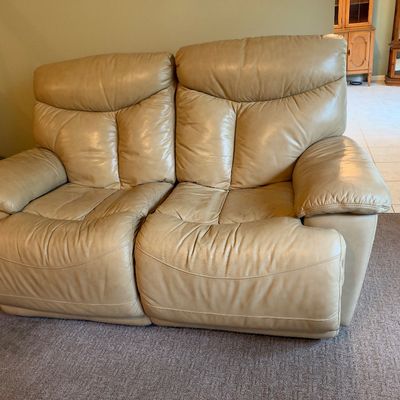 Sale Photo Thumbnail #35: Contemporary beige leather reclining loveseat featuring plush overstuffed cushions and padded armrests.