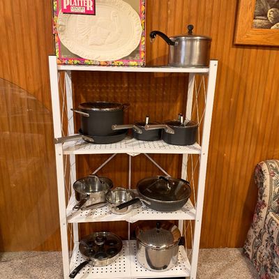Sale Photo Thumbnail #109: Four-tier white metal rolling baker's rack displayed with various cookware, including nonstick and stainless steel pots and pans, alongside a boxed turkey platter.