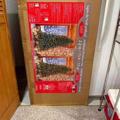 Sale Photo Thumbnail #115: 7.5-foot artificial Christmas tree in its original cardboard box, featuring multi-color and warm white LED lighting options.