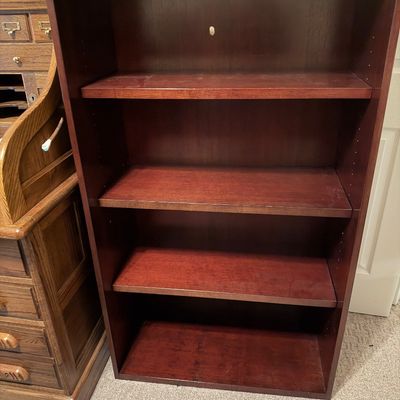 Sale Photo Thumbnail #44: Traditional dark cherry wood bookcase featuring four adjustable shelves, displayed next to a roll-top desk.