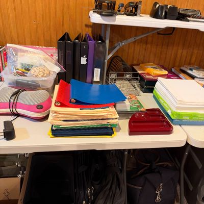 Sale Photo Thumbnail #101: Assortment of office and school supplies including three-ring binders, file folders, printer paper, a neck massager, and desktop organizers arranged on folding tables.