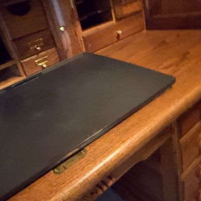 Sale Photo Thumbnail #40: Vintage solid oak roll-top desk with a black leather writing surface pad and detailed interior cubbies.