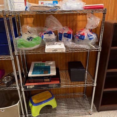 Sale Photo Thumbnail #118: Four-tier wire shelving unit filled with disposable party goods, paper plates, napkins, and miscellaneous household items.