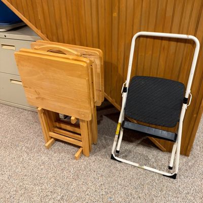 Sale Photo Thumbnail #120: Set of light oak folding TV tray tables on a matching storage rack alongside a Cosco white metal step stool.