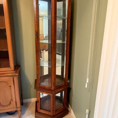 Sale Photo Thumbnail #4: Traditional wooden hexagonal curio cabinet featuring interior glass shelves, glass panel sides, and a mirrored back with lower storage.