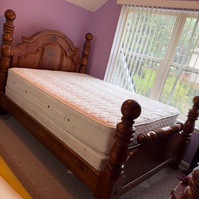 Sale Photo Thumbnail #49: Traditional wooden four-poster bed frame featuring turned finials and an arched headboard, complete with a mattress set.