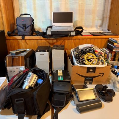 Sale Photo Thumbnail #98: Collection of vintage electronics, including a Panasonic stereo receiver, speakers, a portable DVD player, a camcorder with case, cables, and various media.