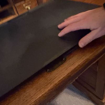 Sale Photo Thumbnail #41: Black leather desk blotter resting on a vintage oak desk, shown in good pre-owned condition.