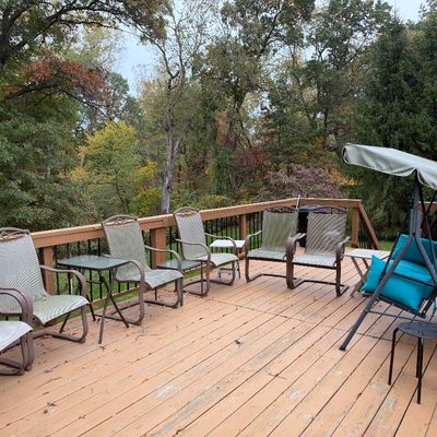 Sale Photo Thumbnail #92: Outdoor deck patio furniture collection including mesh spring-motion armchairs, small glass-top side tables, and a canopy porch swing with teal cushions.