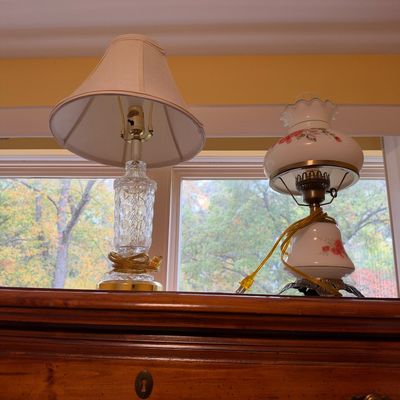 Sale Photo Thumbnail #51: Two vintage table lamps, including a cut crystal lamp with a fabric shade and a floral hand-painted hurricane-style Gone with the Wind lamp, displayed on a wooden chest.