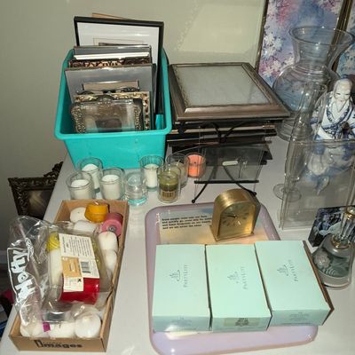 Sale Photo Thumbnail #71: Collection of home decor items including PartyLite candle boxes, clear glass votive holders, assorted picture frames, an arched brass desk clock, and a porcelain figurine.