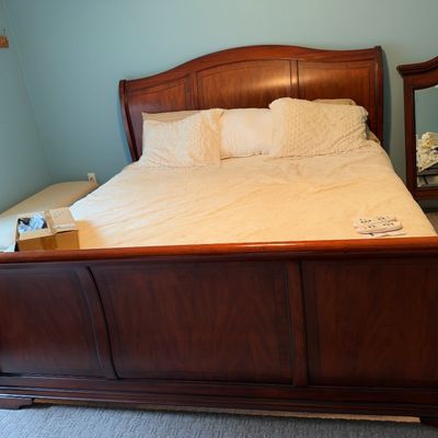 Sale Photo Thumbnail #33: Traditional wooden sleigh bed frame featuring panel detailing, accompanied by a matching framed wall mirror visible in the background.