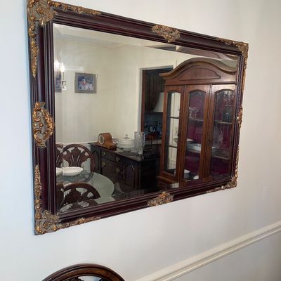 Large ornate rectangular wall mirror featuring a mahogany-finished frame with gilded corner and edge accents.