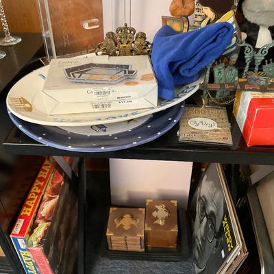 Sale Photo Thumbnail #21: Assortment of Judaica collectibles, including ceramic plates, a menorah, figurine decor, board games, and small brass-fitted wooden boxes.