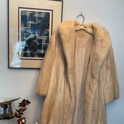 Sale Photo Thumbnail #141: Vintage mid-century blonde mink fur coat with a wide shawled collar and embroidered satin lining, displayed on a wall hanger.