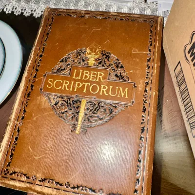 Antique copy of 'Liber Scriptorum: The First Book of the Authors Club,' featuring an ornate embossed leather cover with gilded...