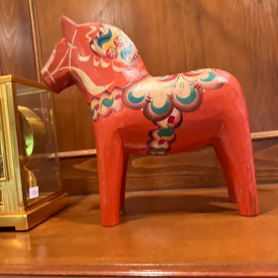 Vintage hand-painted Swedish Dala horse figurine in traditional red with blue, green, and white kurbits detailing.