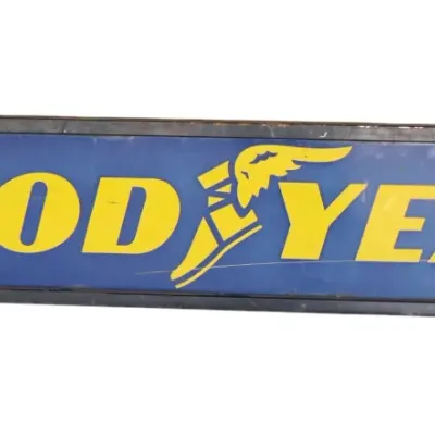 Sale Photo Thumbnail #263: Vintage Goodyear tires advertising sign featuring yellow lettering and the winged foot logo on a blue background, set in a metal frame.
