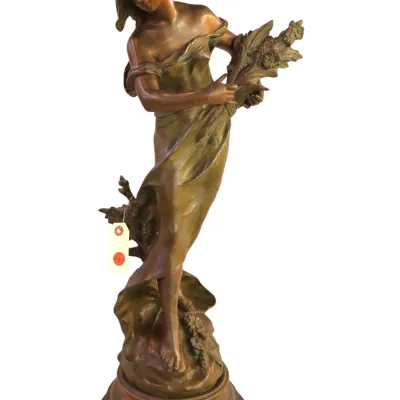 Sale Photo Thumbnail #101: Art Nouveau style patinated bronze statue depicting a maiden gathering wheat, mounted on a round tiered base.
