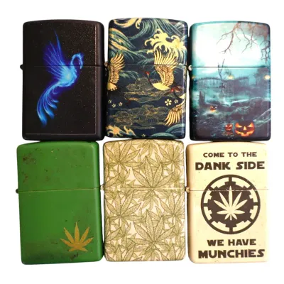 Sale Photo Thumbnail #167: Collection of six modern flip-top lighters featuring various graphic designs, including cannabis leaf motifs, Japanese waves and cranes, a glowing phoenix, and a Halloween theme.