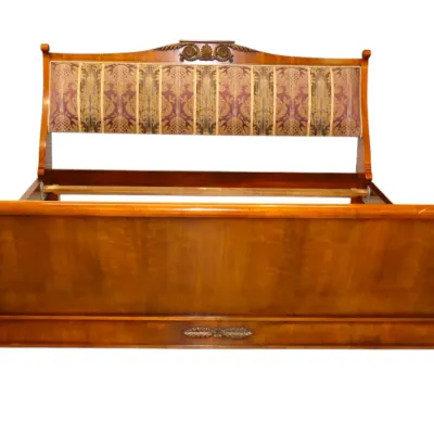 Sale Photo Thumbnail #231: French Neoclassical style wood sleigh bed frame featuring carved leaf accents and a partially upholstered headboard with striped damask fabric.