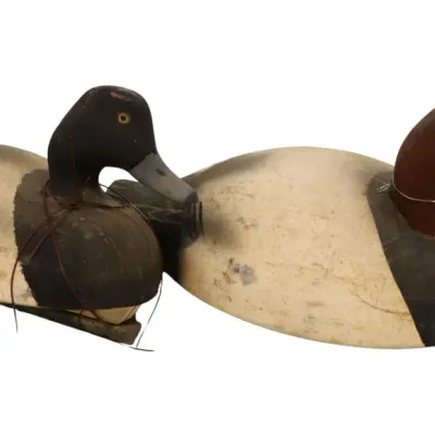 Sale Photo Thumbnail #91: Pair of vintage hand-carved wooden duck decoys with distressed painted finishes and glass eyes.