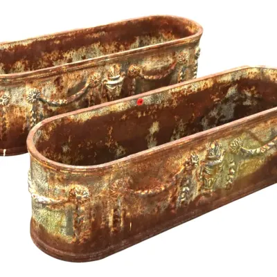 Sale Photo Thumbnail #54: Pair of antique cast iron oval trough planters featuring classical garland, urn, and rosette relief details with heavy rusted patina.