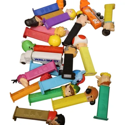 Sale Photo Thumbnail #118: Assorted collection of vintage and modern PEZ dispensers featuring cartoon characters, sports icons, and promotional vehicles.