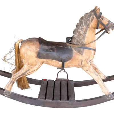 Sale Photo Thumbnail #257: Antique carved wooden rocking horse with a dark leather saddle, leather tack, horsehair tail, and a dark wooden rocker base.