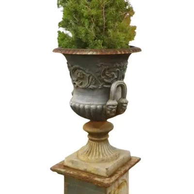 Sale Photo Thumbnail #56: Vintage classical cast iron garden urn planter on a square plinth base, featuring decorative acanthus scrollwork, side handles, and a weathered patina.