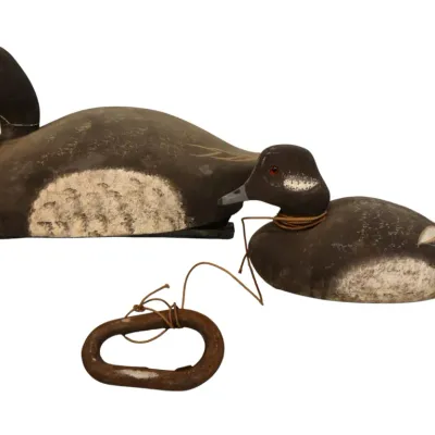 Sale Photo Thumbnail #88: Pair of vintage hand-carved painted wooden duck decoys with glass eyes, including one with attached string and weight.