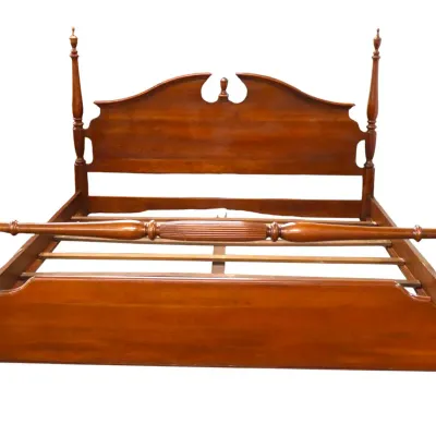 Sale Photo Thumbnail #232: Traditional wooden four-poster bed frame featuring turned posts with finials, a camelback-style headboard, and a turned stretcher bar.