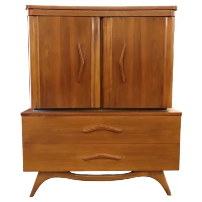 Sale Photo Thumbnail #35: Mid-century modern walnut boomerang  armoire chest featuring an upper two-door cabinet with stylized wooden pulls over two lower drawers and a curved base.