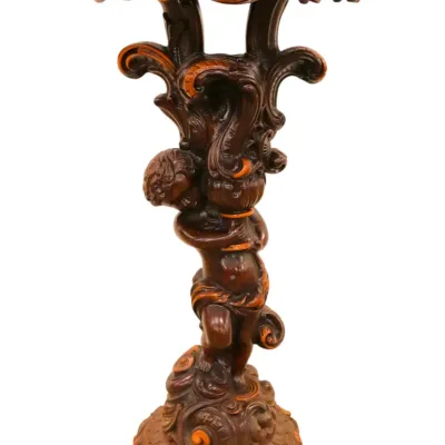 Sale Photo Thumbnail #244: Ornate carved dark wood pedestal featuring a cherub figure and baroque-style acanthus scrollwork.