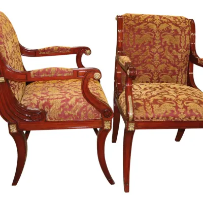 Sale Photo Thumbnail #273: Pair of Neoclassical or Empire style mahogany armchairs featuring scrolled arms, gilt rosettes, curved sabre legs, and red and gold woven tapestry upholstery with animal motifs.