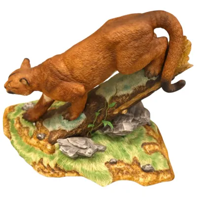 Sale Photo Thumbnail #293: Hand-painted porcelain or resin figurine depicting a stalking cougar on a log and rocky terrain base, displaying fine textured fur details.